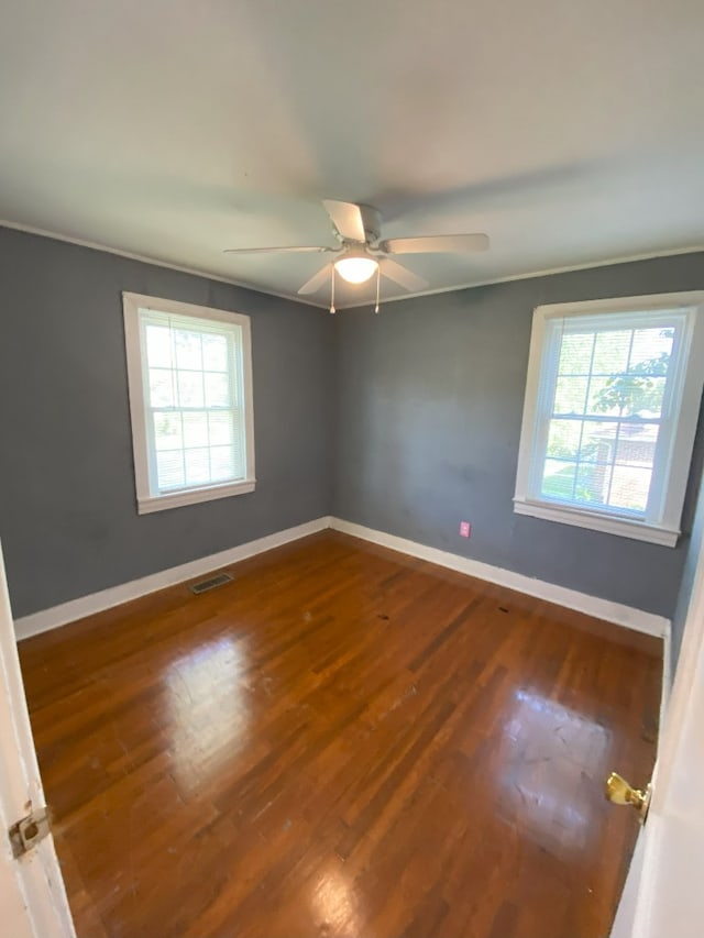 unfurnished room with ceiling fan, crown molding, a wealth of natural light, and hardwood / wood-style floors