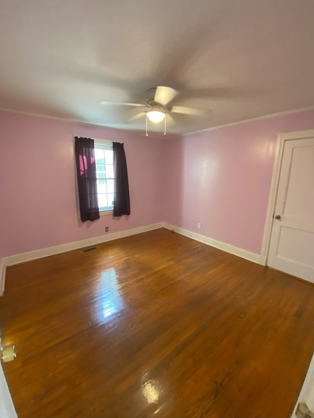 spare room with ornamental molding, ceiling fan, and dark hardwood / wood-style flooring