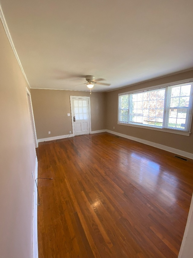 empty room featuring crown molding, ceiling fan, and dark hardwood / wood-style flooring