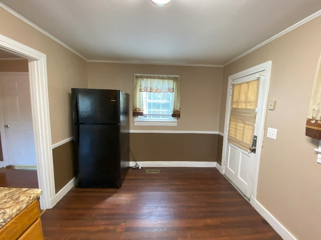 kitchen with dark hardwood / wood-style flooring, crown molding, light stone countertops, and black fridge