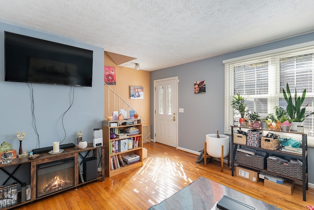 living room featuring a healthy amount of sunlight, hardwood / wood-style flooring, and a textured ceiling