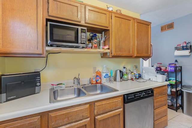 kitchen featuring stainless steel appliances, sink, and light tile patterned flooring