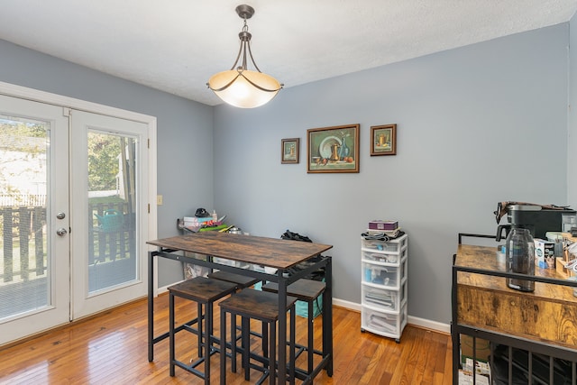 dining room with french doors, a textured ceiling, and wood-type flooring