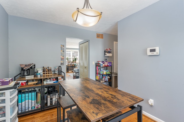 office with light hardwood / wood-style floors and a textured ceiling