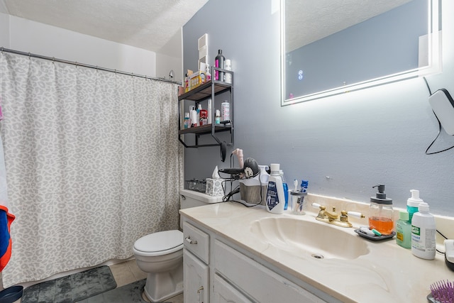 bathroom with vanity, a textured ceiling, toilet, and tile patterned floors