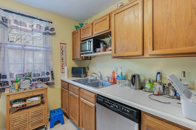 kitchen featuring light tile patterned flooring, sink, and stainless steel dishwasher