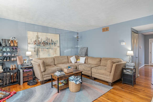 living room with light hardwood / wood-style flooring and a textured ceiling