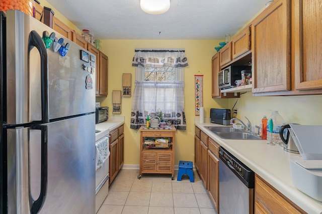 kitchen featuring light tile patterned floors, appliances with stainless steel finishes, and sink