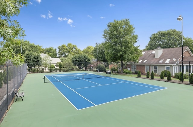 view of tennis court with basketball hoop