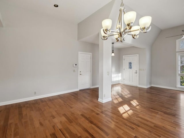 interior space with ceiling fan with notable chandelier, dark wood-type flooring, and vaulted ceiling