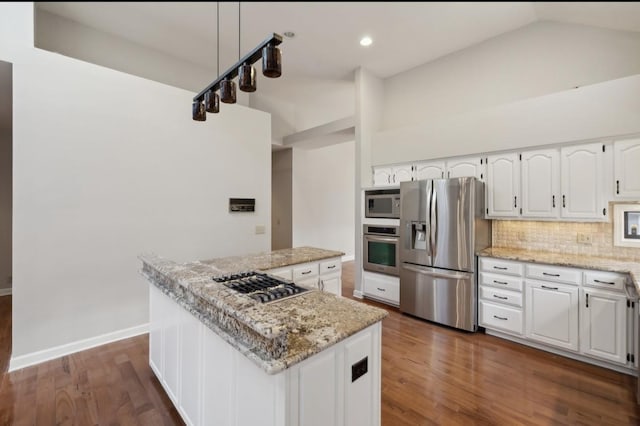 kitchen featuring white cabinets, stainless steel appliances, a kitchen island, and light stone countertops