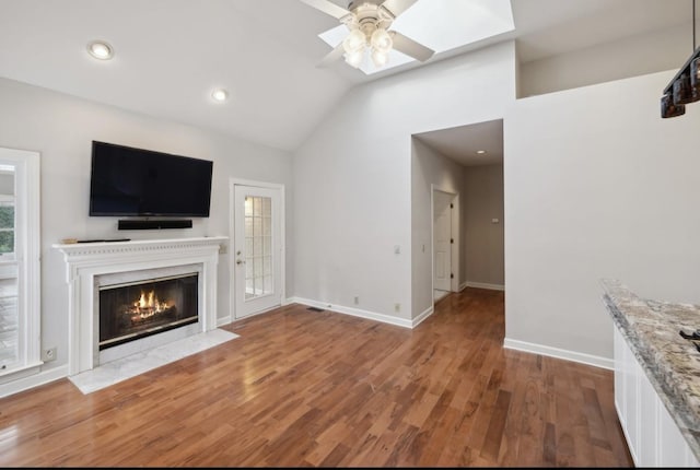 unfurnished living room featuring hardwood / wood-style floors, ceiling fan, and lofted ceiling