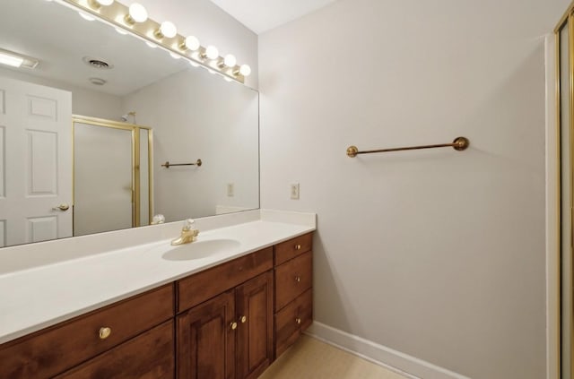 bathroom with vanity and a shower with door