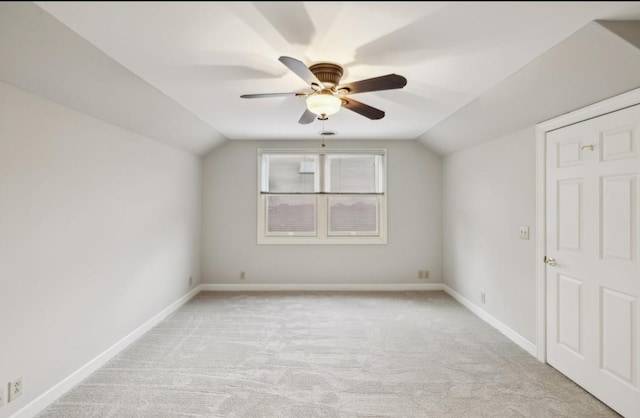 additional living space featuring light colored carpet, ceiling fan, and lofted ceiling