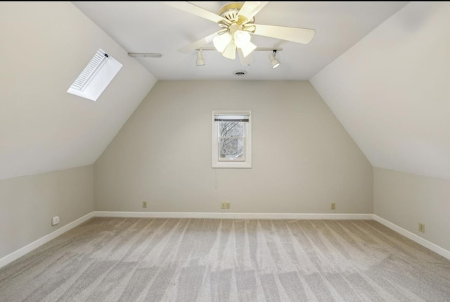 additional living space featuring lofted ceiling with skylight, ceiling fan, and light colored carpet