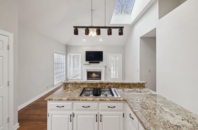 kitchen featuring white cabinetry, stainless steel gas cooktop, dark hardwood / wood-style flooring, lofted ceiling, and decorative light fixtures