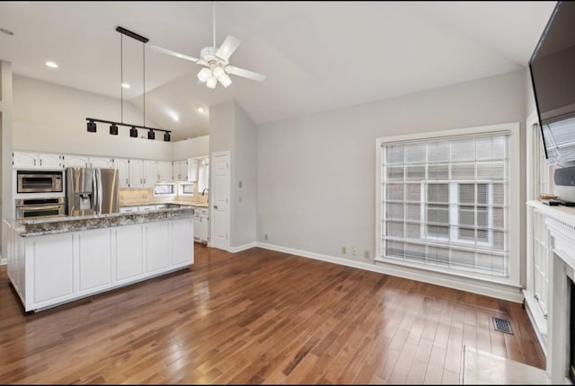 kitchen with white cabinets, dark hardwood / wood-style floors, ceiling fan, light stone countertops, and appliances with stainless steel finishes