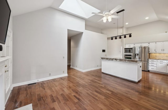 kitchen featuring high vaulted ceiling, white cabinets, a skylight, dark hardwood / wood-style flooring, and stainless steel appliances