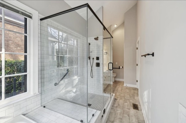 bathroom featuring toilet and a shower with door