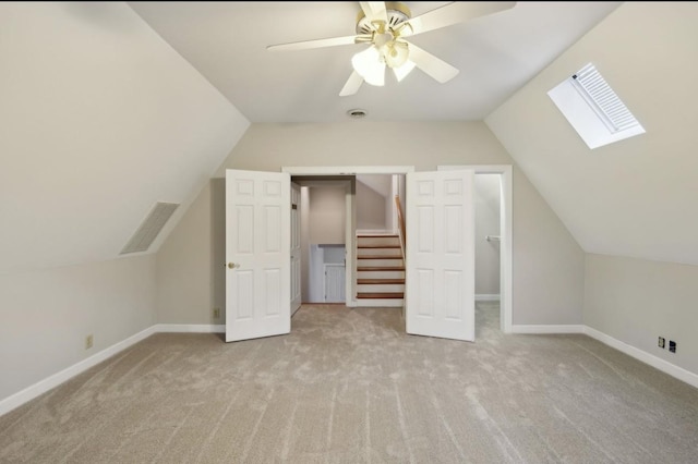 bonus room featuring light colored carpet, ceiling fan, and vaulted ceiling with skylight