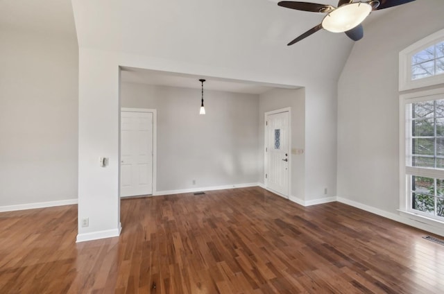 empty room featuring ceiling fan, dark wood-type flooring, and lofted ceiling