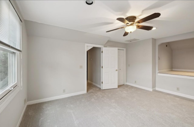 unfurnished bedroom with ceiling fan, light colored carpet, and lofted ceiling