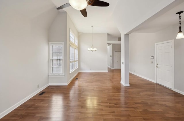 unfurnished living room featuring dark hardwood / wood-style floors, ceiling fan with notable chandelier, and vaulted ceiling