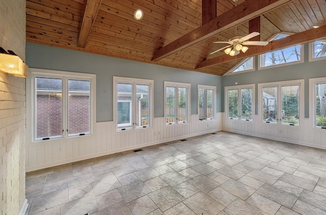 unfurnished sunroom featuring lofted ceiling with beams, plenty of natural light, wooden ceiling, and ceiling fan