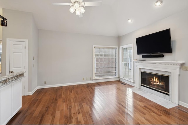 unfurnished living room featuring hardwood / wood-style floors, ceiling fan, and vaulted ceiling