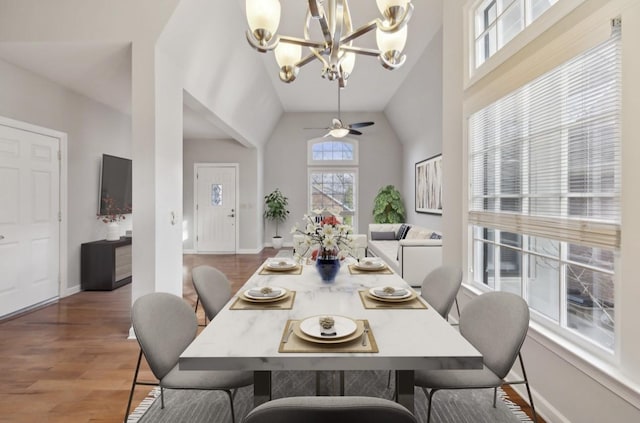 dining room featuring hardwood / wood-style flooring, ceiling fan with notable chandelier, and lofted ceiling