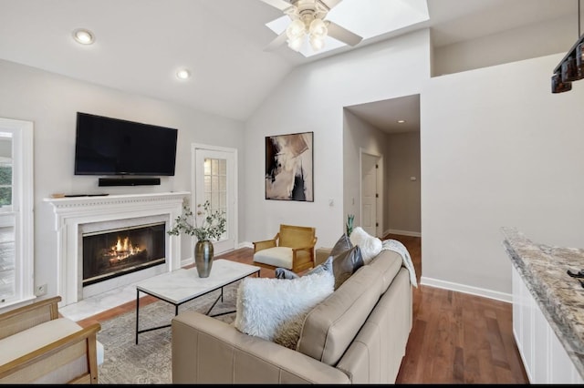 living room with hardwood / wood-style flooring, ceiling fan, and lofted ceiling