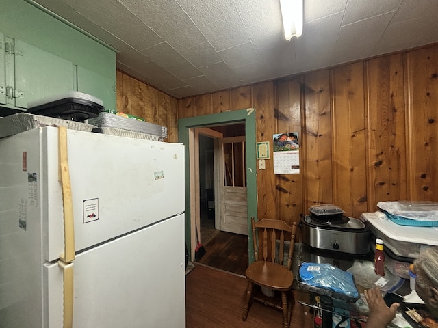 kitchen featuring wood walls, dark hardwood / wood-style floors, and white refrigerator