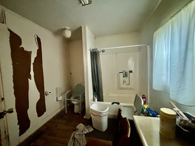 bathroom with hardwood / wood-style flooring and shower / bath combo with shower curtain