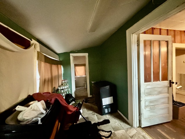 interior space with lofted ceiling and wooden walls