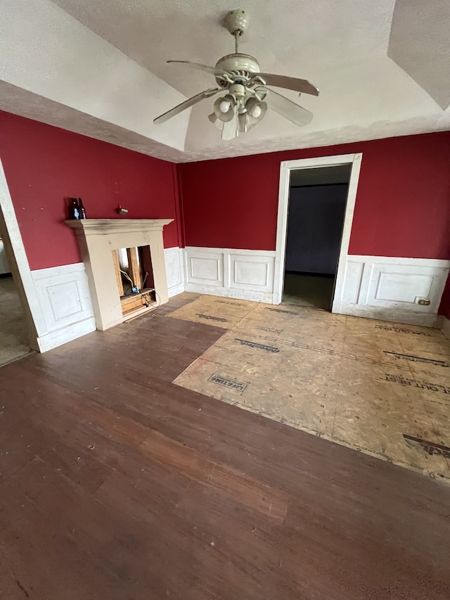 unfurnished living room featuring ceiling fan, a textured ceiling, and dark hardwood / wood-style flooring