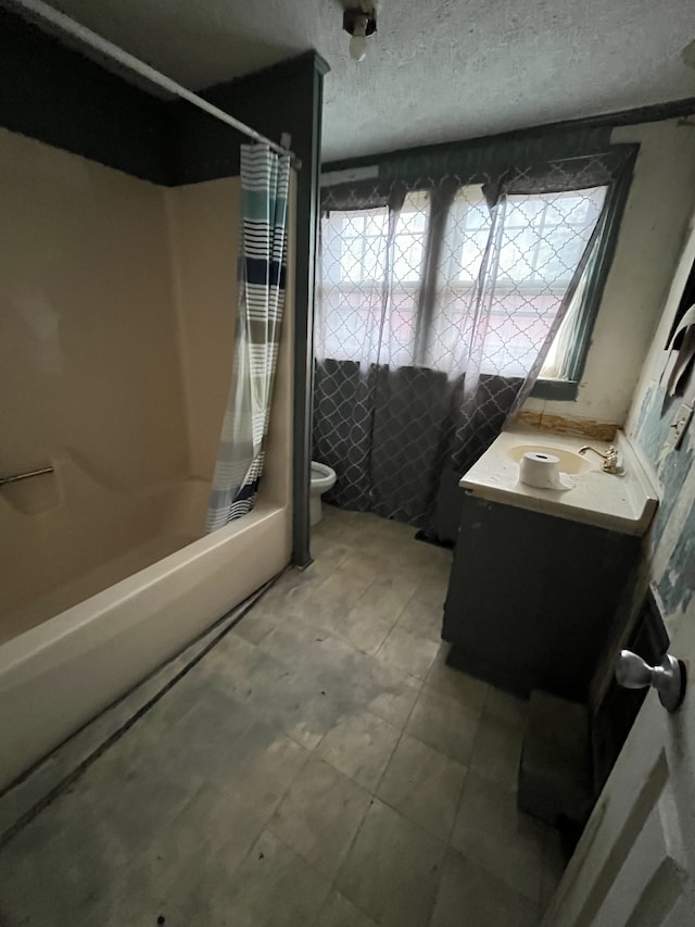 full bathroom featuring vanity, shower / bath combo, toilet, and a textured ceiling