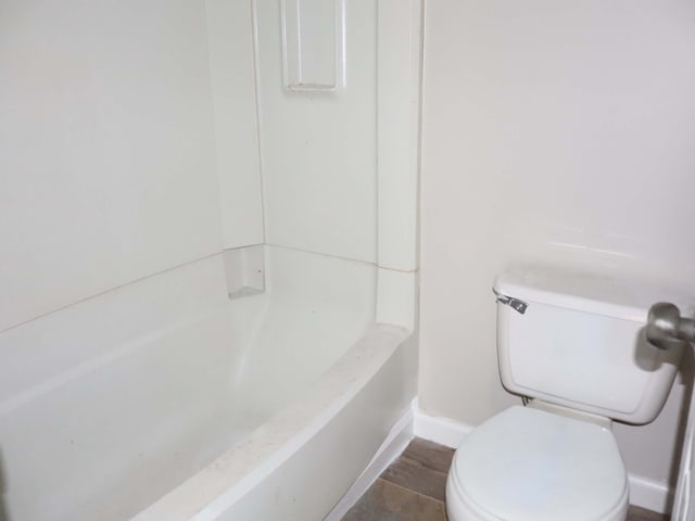 bathroom with toilet, a bathtub, and tile patterned flooring