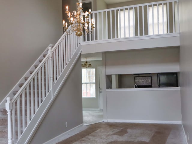 stairs featuring a towering ceiling and carpet flooring