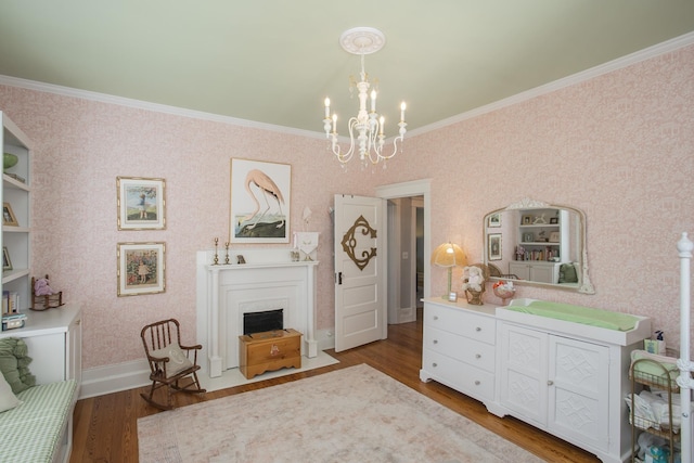 sitting room featuring dark hardwood / wood-style floors, crown molding, and a chandelier