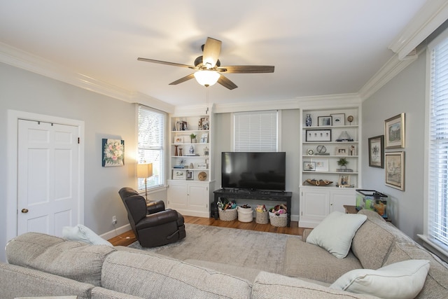 living room featuring ceiling fan, hardwood / wood-style floors, built in features, and crown molding