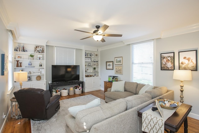 living room featuring ceiling fan, hardwood / wood-style flooring, built in features, and crown molding