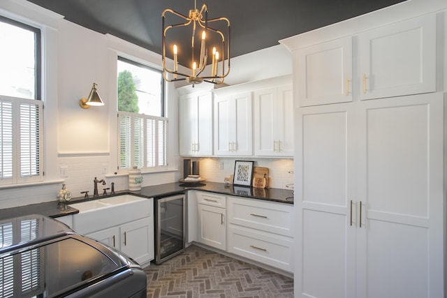 kitchen featuring pendant lighting, a wealth of natural light, white cabinets, and wine cooler