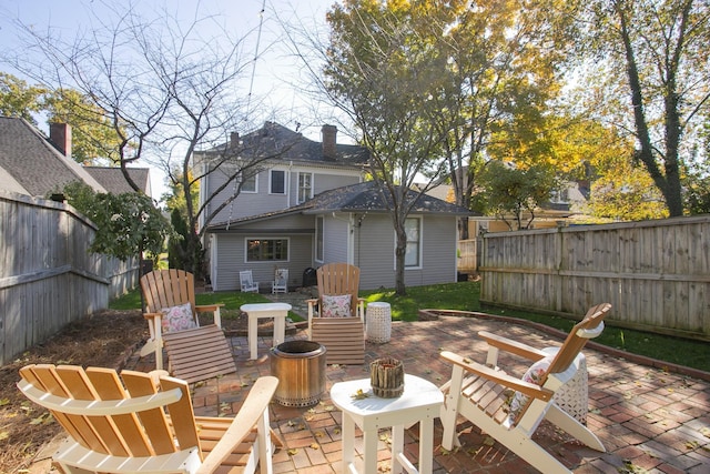 back of house with a fire pit and a patio