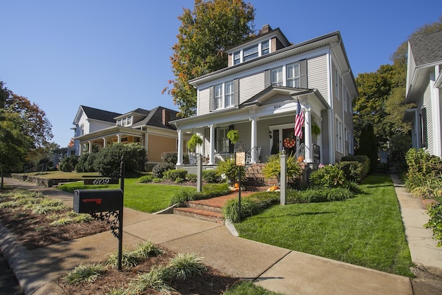 view of front of property with covered porch and a front lawn