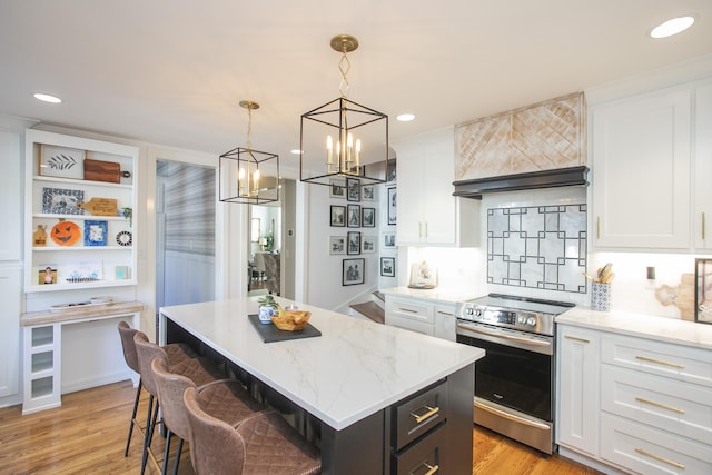 kitchen featuring hanging light fixtures, a kitchen island, white cabinetry, and stainless steel range with electric stovetop