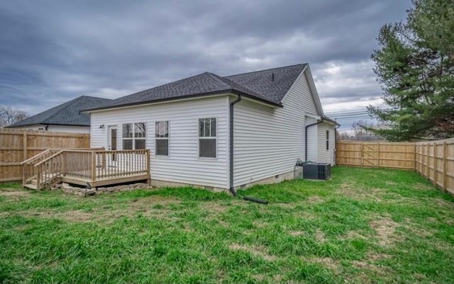 rear view of house with a yard, a wooden deck, and central air condition unit