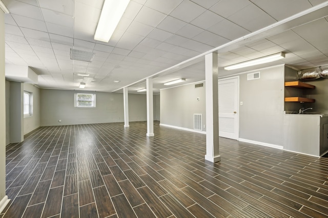 basement with sink and dark wood-type flooring