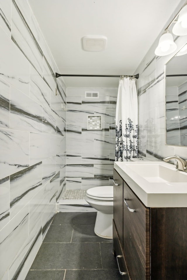 bathroom with tile walls, vanity, a shower with curtain, and toilet