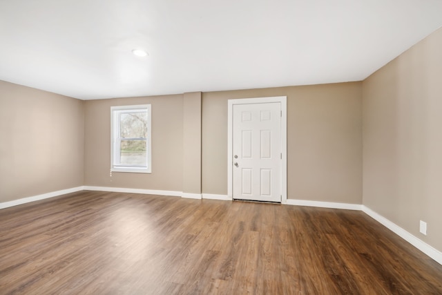 empty room with dark hardwood / wood-style flooring