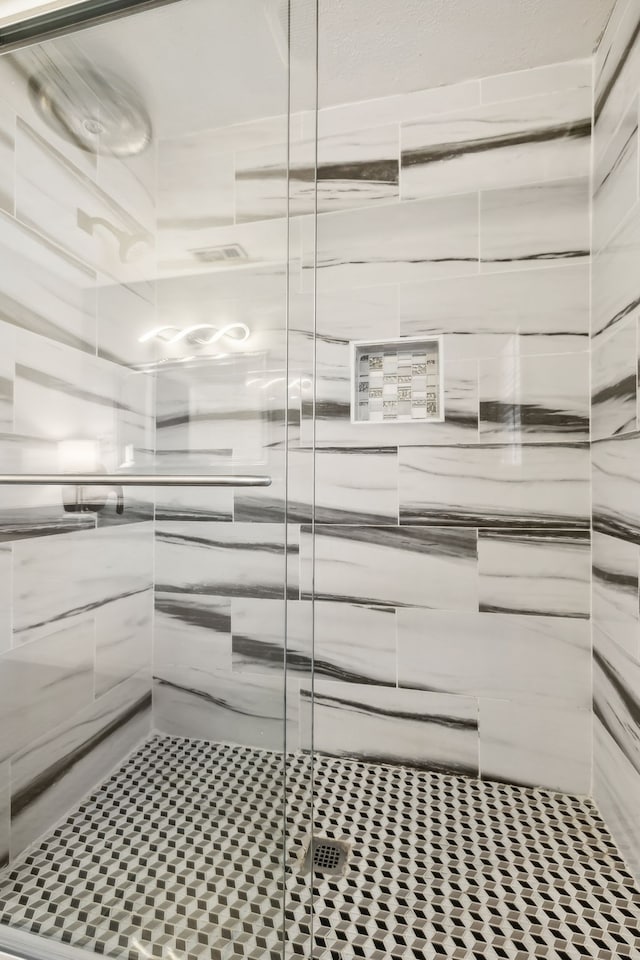 bathroom with a shower with shower door and tile patterned flooring